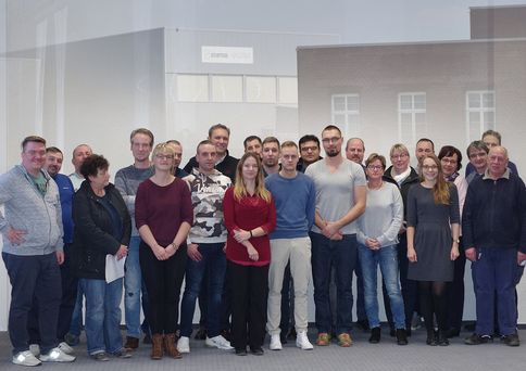 Eine große Gruppe von Menschen steht frontal zur Kamera