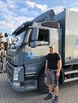 Ein junger Mann steht vor einem grauen LKW der Getränkehandel Köthen GmbH