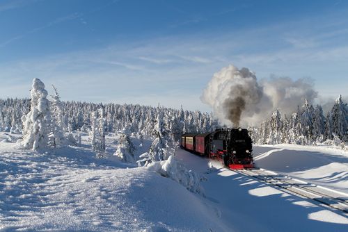 Die Brockenbahn fährt durch eine winterliche Lsnadschaft