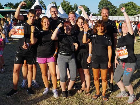 Zehn Mitarbeiterinnen und Mitarbeiter von Umland haben Sportkleidung an. Sie sind glücklich, lachen und schauen jubelnd in die Kamera. Es ist Sommer. Sie haben am Firmenlauf Magdeburg teilgenommen.