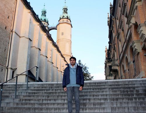 Ein Mann steht auf einer Treppe, hinter ihm eine Kirche.