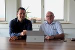 Unsere Digitalisierungsberater Felix Malter (links) und Siegfried Simolke (rechts) sitzen am Tisch an einem Laptop(Foto: Fachkraft im Fokus).