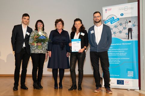 5 Menschen stehen auf einer Bühne